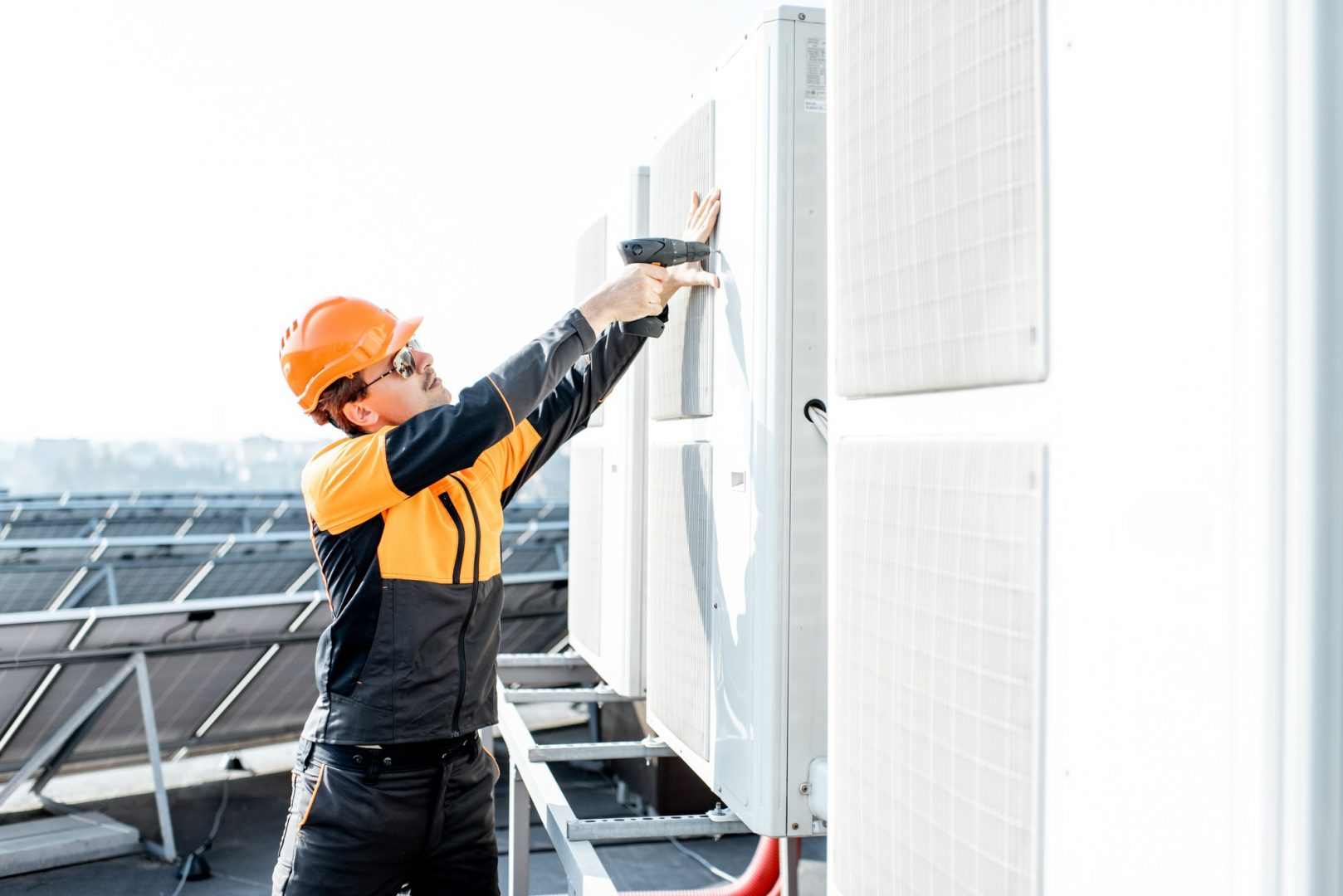 Workman installing outdoor unit of the air conditioner